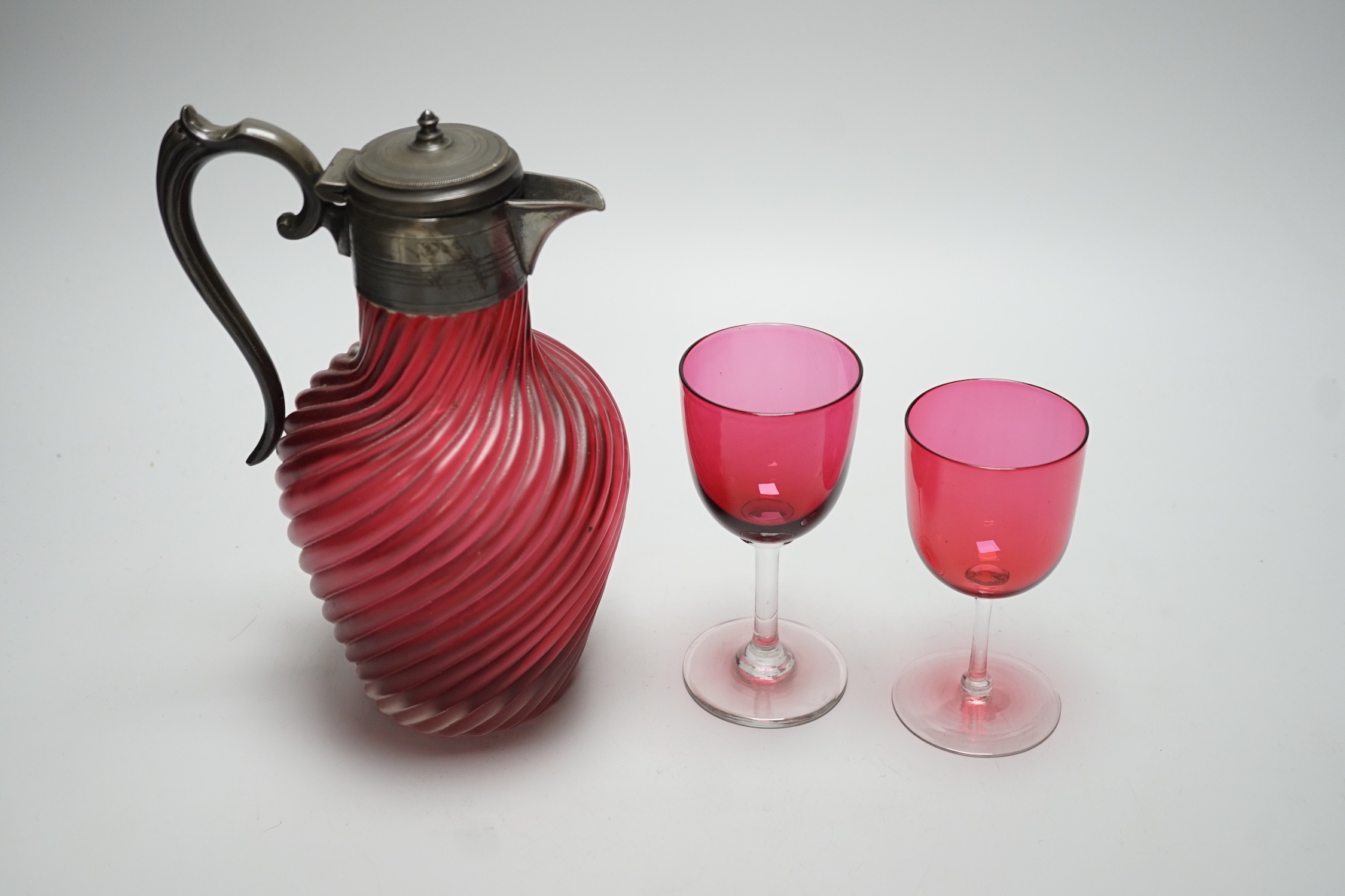 A Victorian wrythen moulded cranberry glass jug, 22cm high, and assorted wine glasses